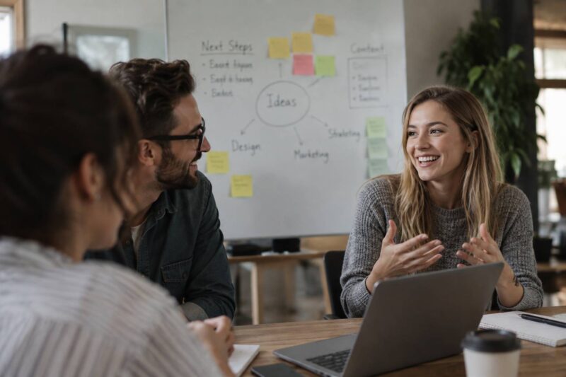 Three colleagues discussing ideas and career development during an office meeting.